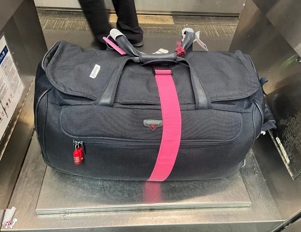 identify suitcase with colorful luggage strap and ID tag